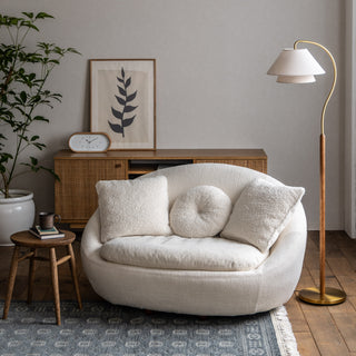 ドレスのようにレイヤードされたシェードと、弧を描く支柱がエレガントなフロアランプ